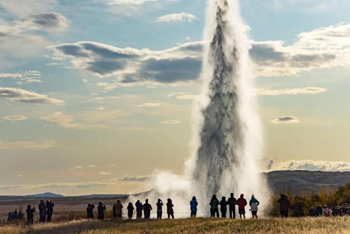 un gruppo di persone in piedi attorno a un geyser