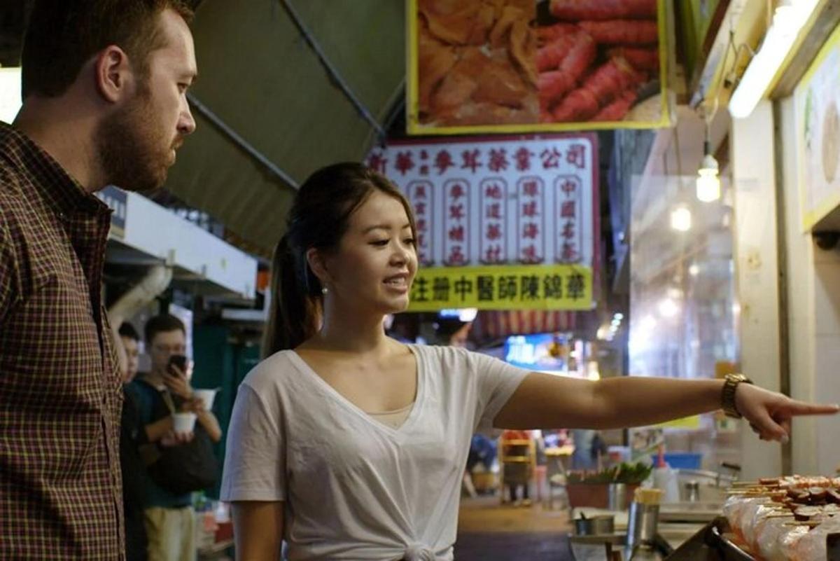 un uomo che indica una donna in un mercato
