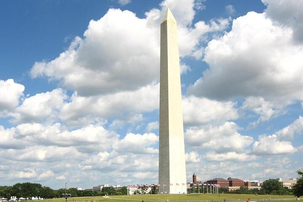 vysoký bílý obelisk na poli se zataženou oblohou
