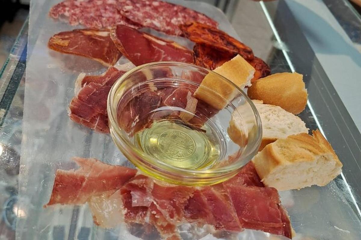 a glass of wine sitting on a tray with meat
