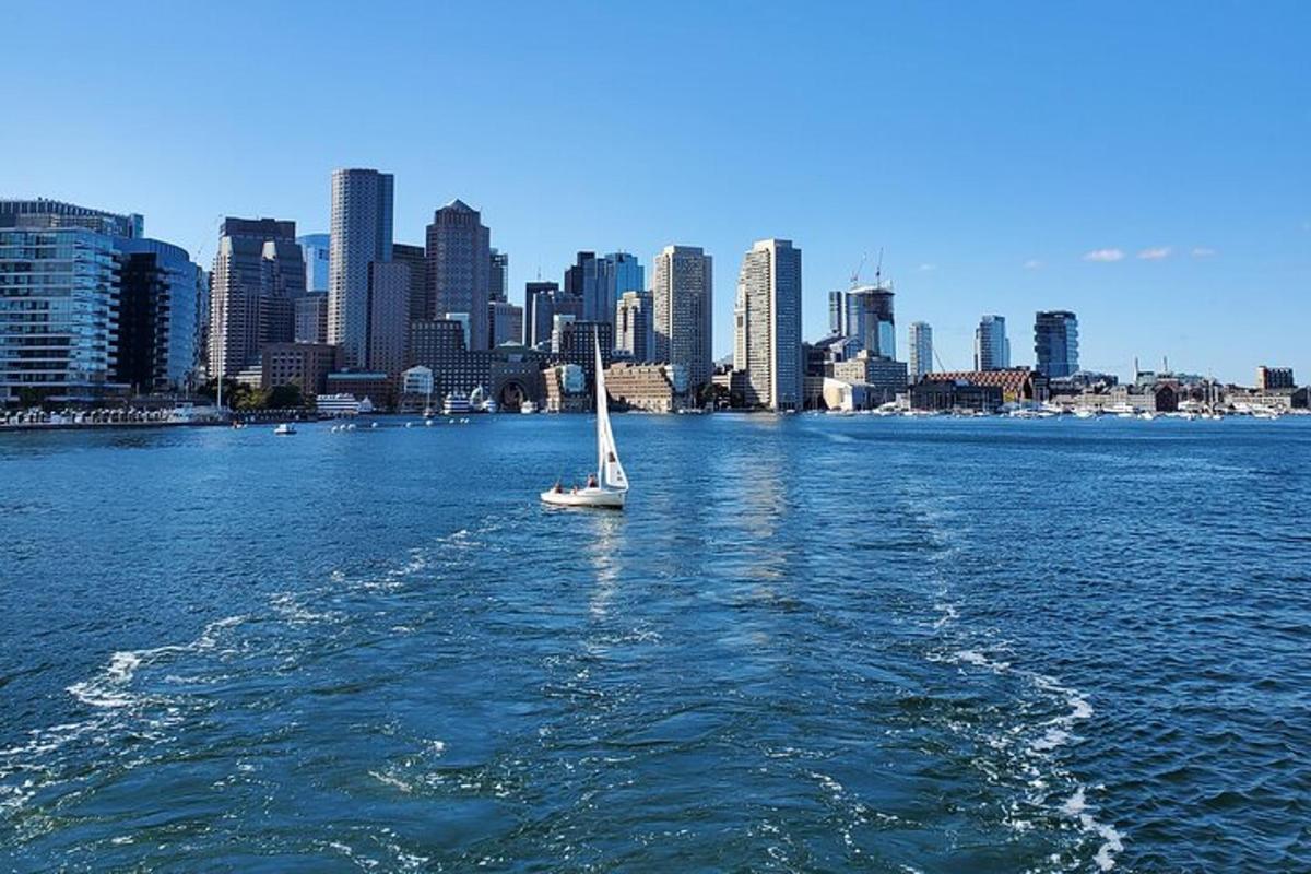 a sailboat in the water in front of a city