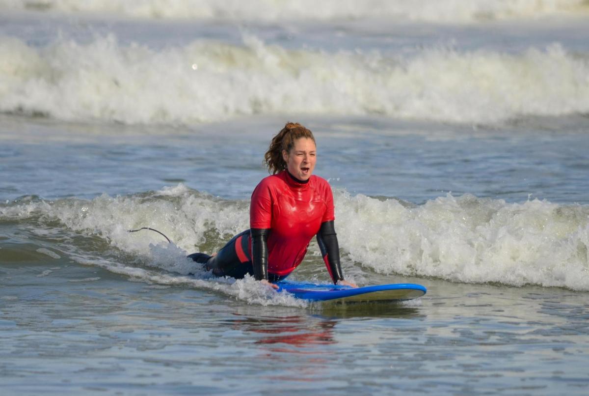 en kvinne som rir på en bølge på et surfebrett i havet