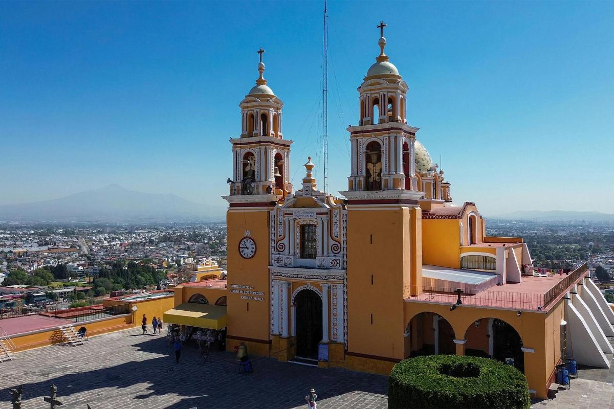 a large yellow building with two towers and a clock