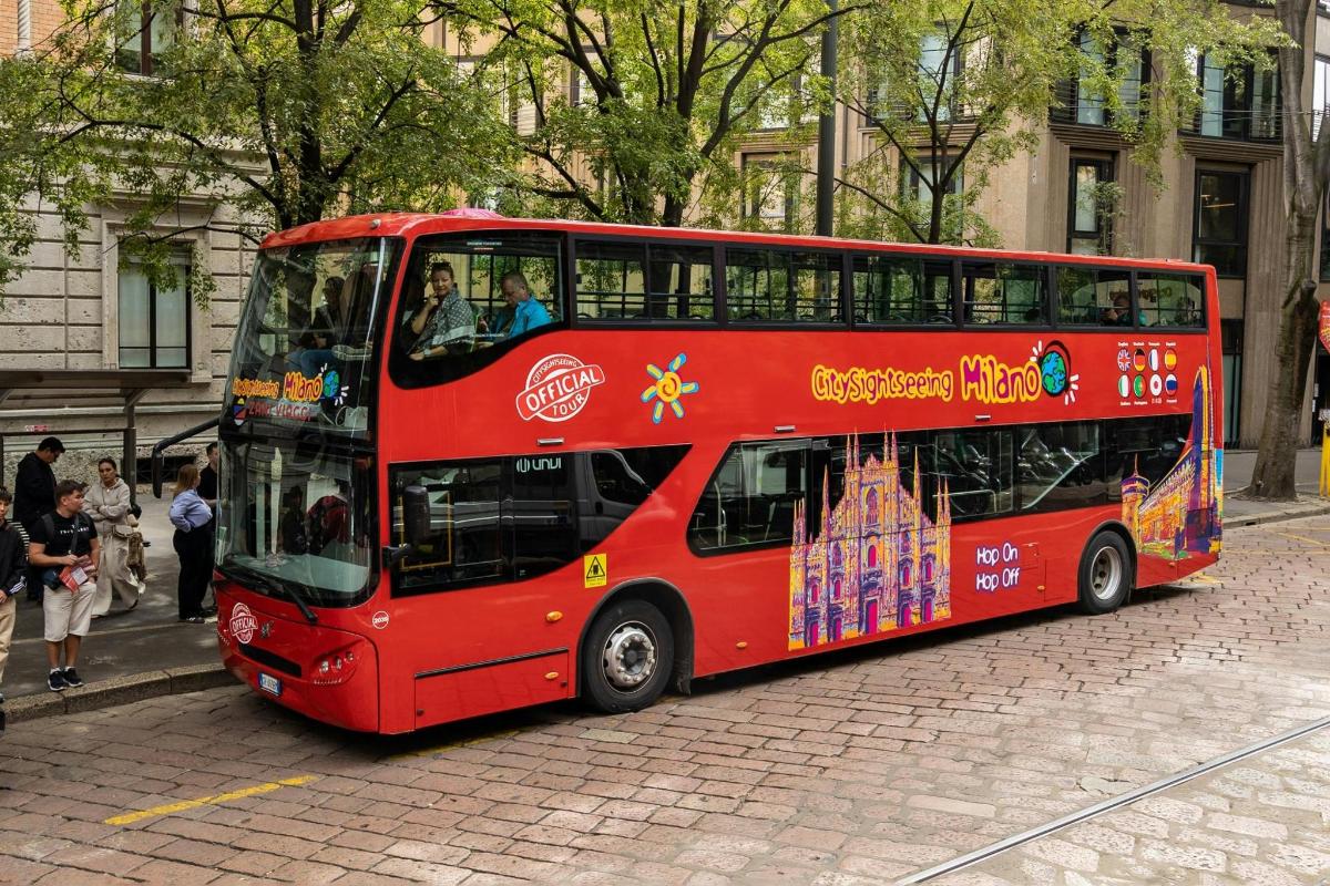 červený dvoupatrový autobus jedoucí po ulici