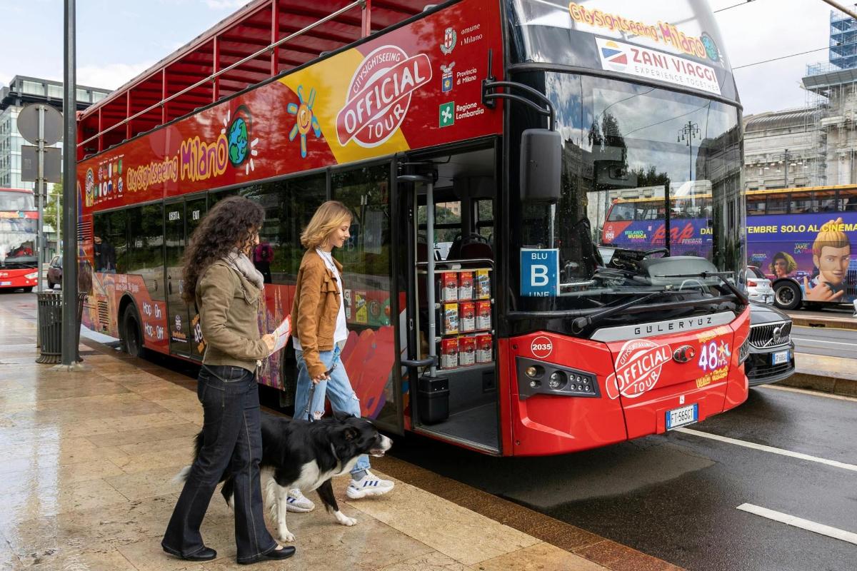 zwei Frauen und ein Hund stehen vor einem Bus