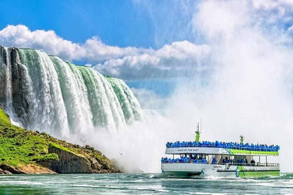 a tour boat in front of a waterfall