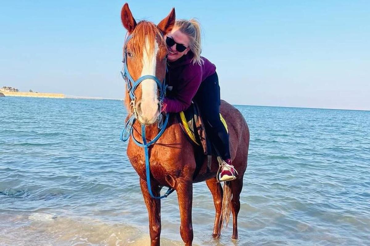 eine Frau, die am Strand reitet