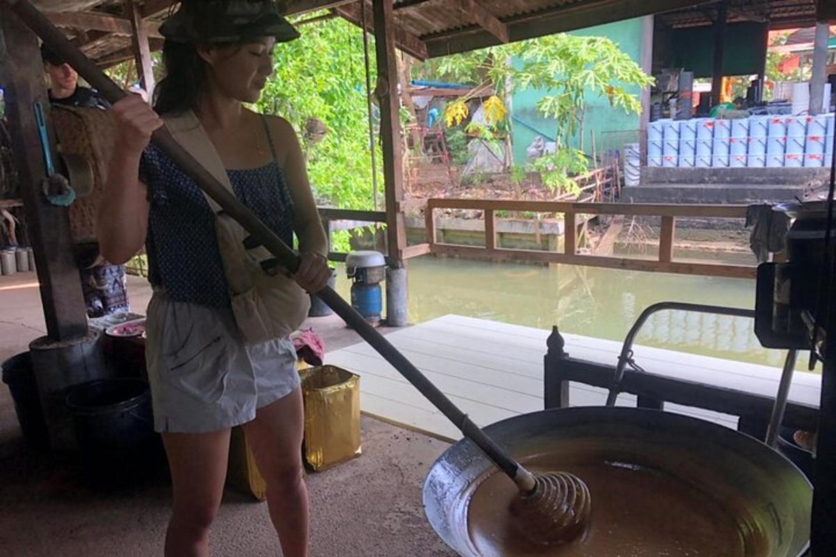 一位女士站在一个大金属锅旁边