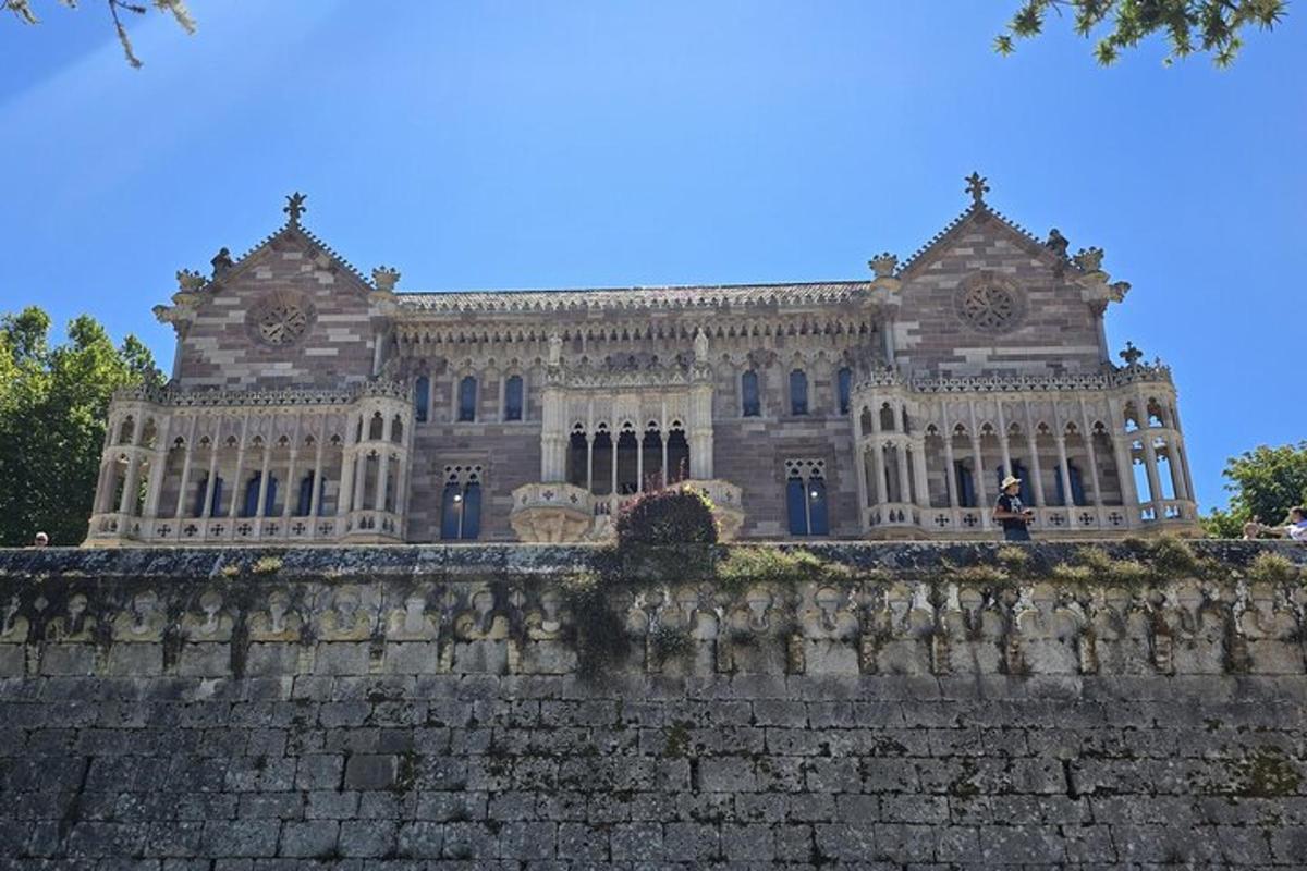 Un gran edificio detrás de una pared de ladrillos con un castillo.