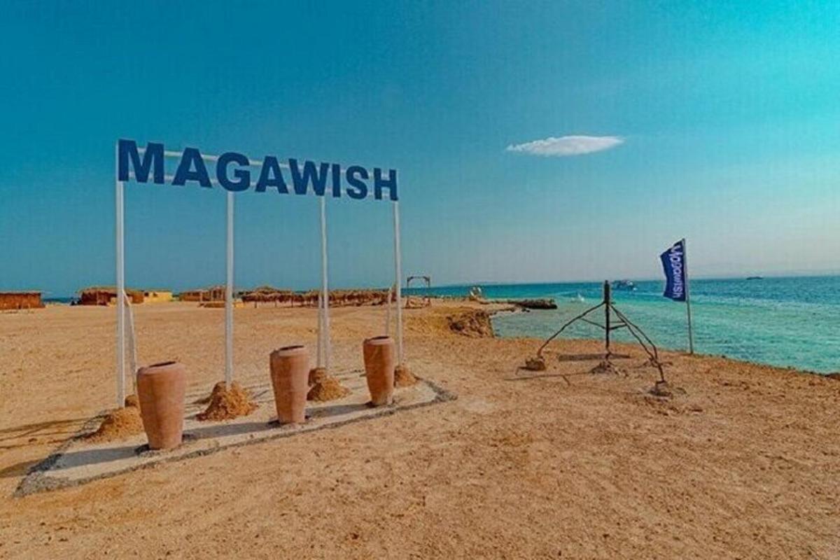un cartello su una spiaggia con l'oceano sullo sfondo