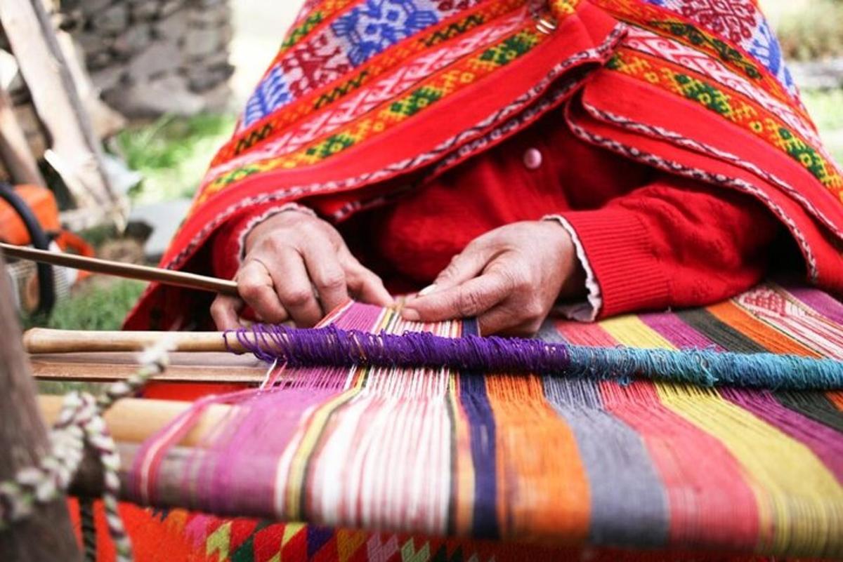 una persona sta lavorando a maglia un pezzo di stoffa con un bastone