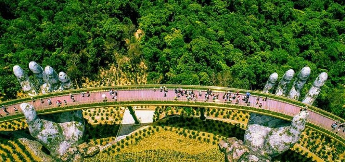un gruppo di persone che camminano su un ponte sopra un giardino