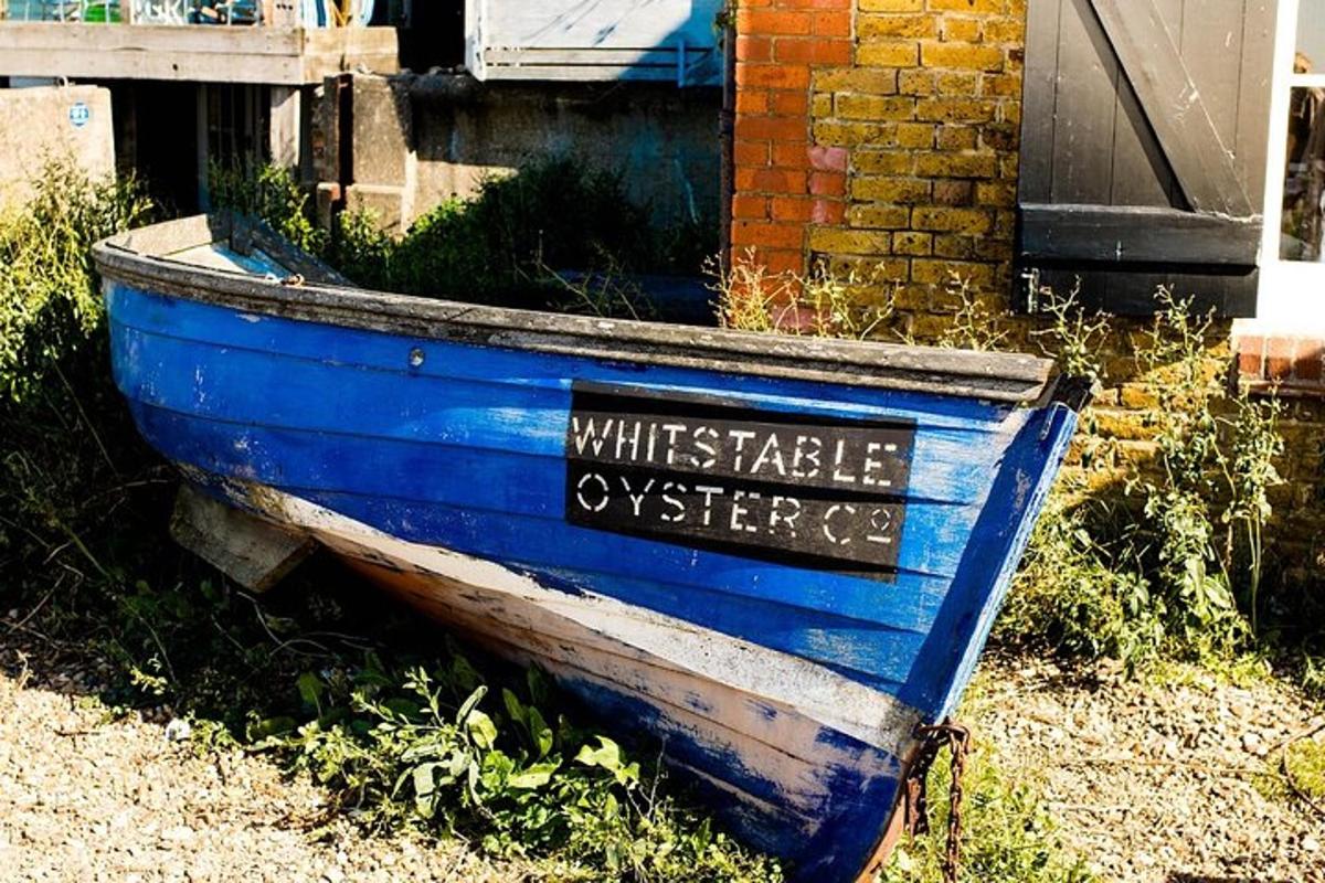 a blue boat sitting in the grass next to a house