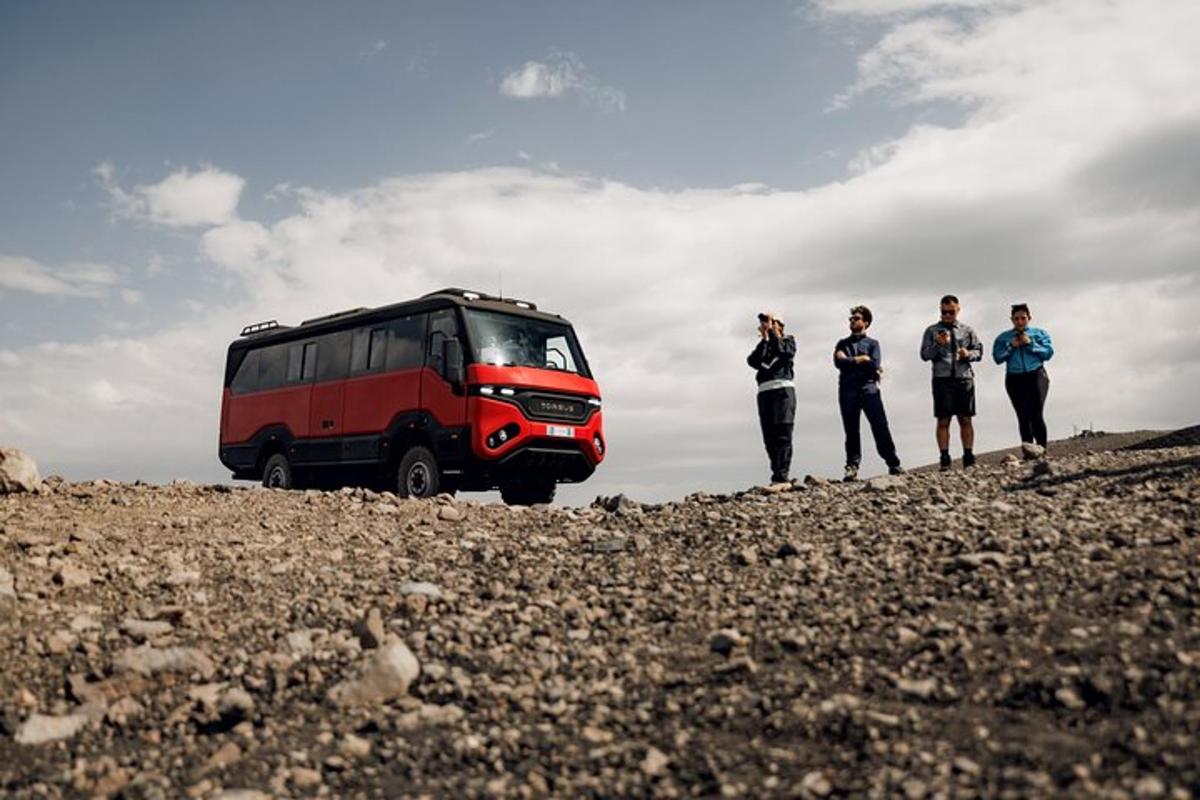 skupina lidí stojící vedle červeného autobusu