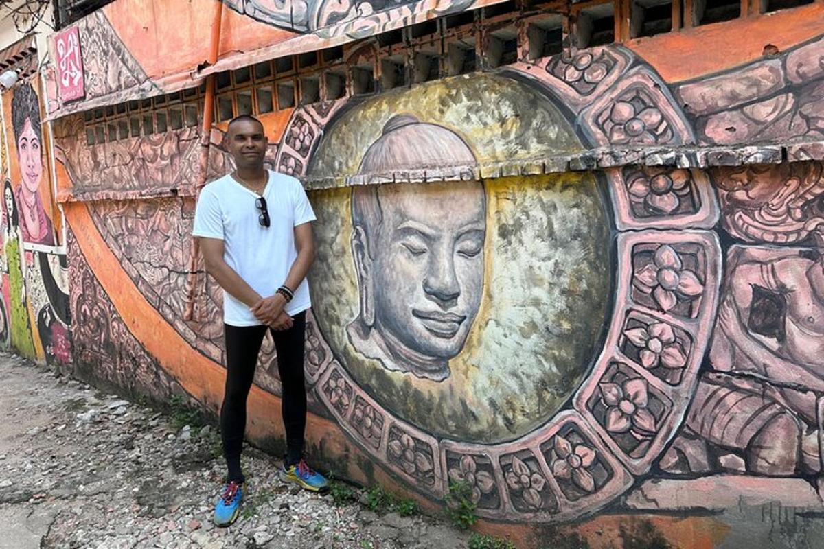 muž stojící před zdí s nástěnnou malbou