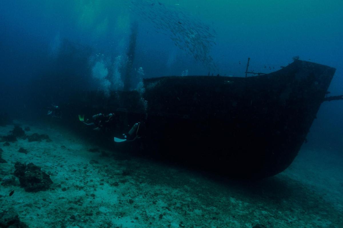 a boat in the ocean next to a reef