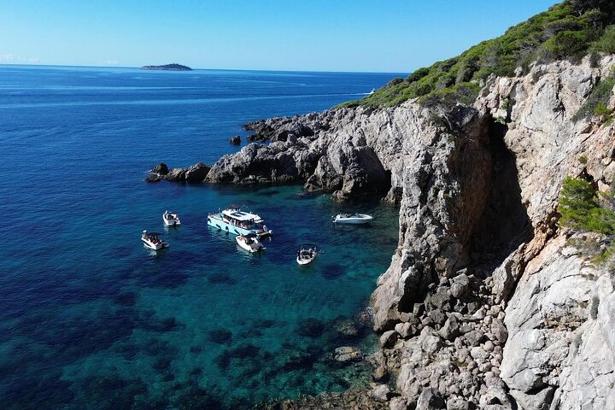 Μια ομάδα σκαφών στο νερό κοντά σε έναν απότομο βράχο