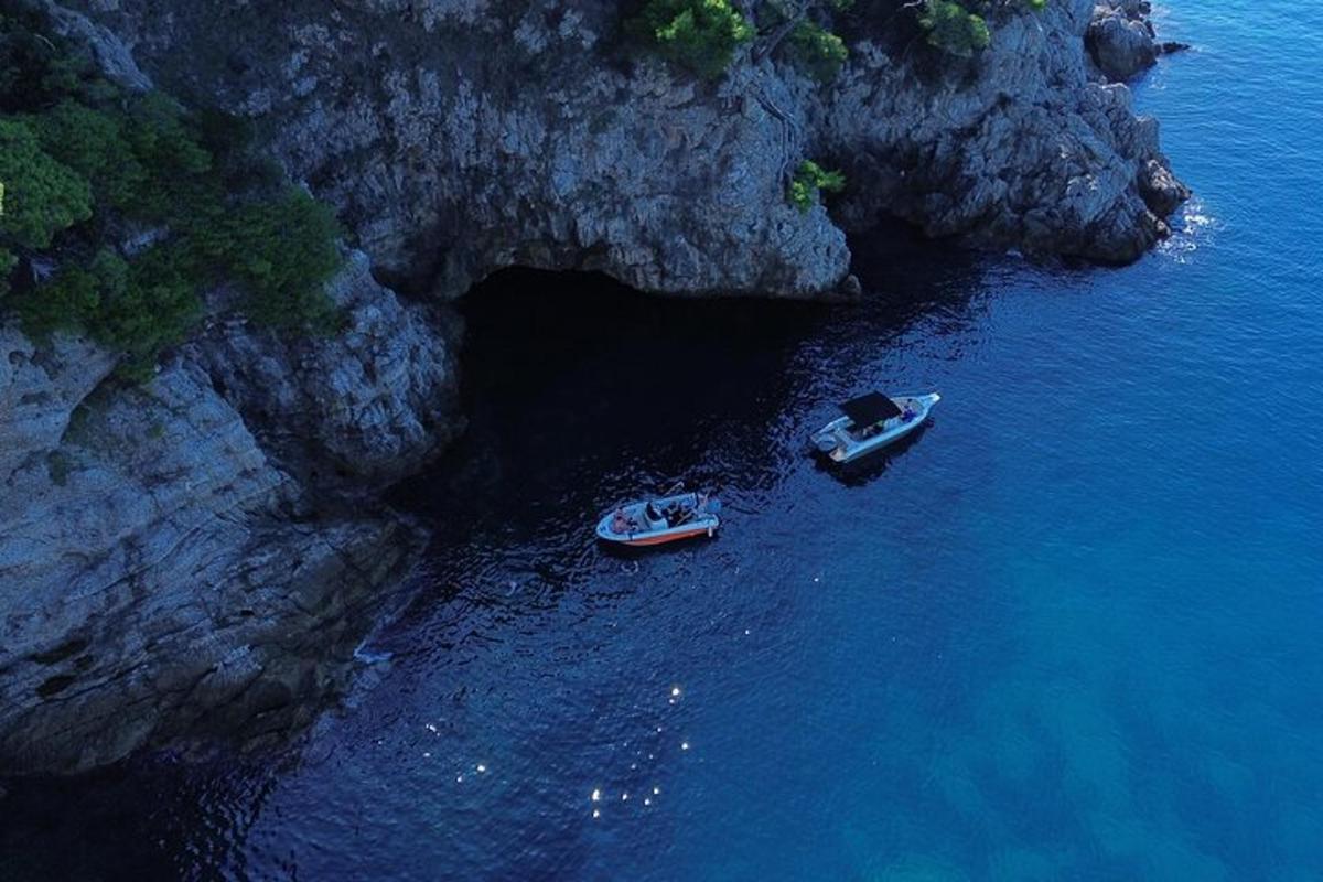 δύο βάρκες στο νερό δίπλα σε μια σπηλιά
