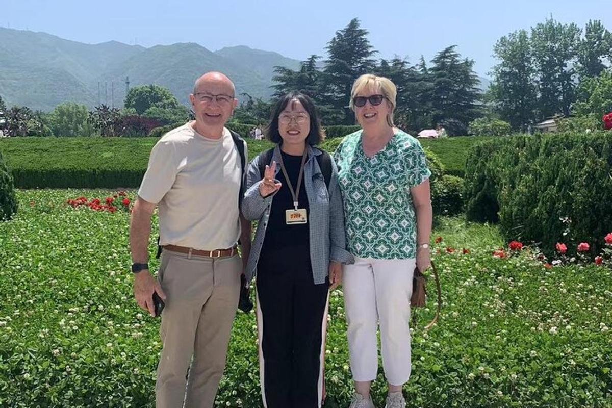a group of three people standing in a garden