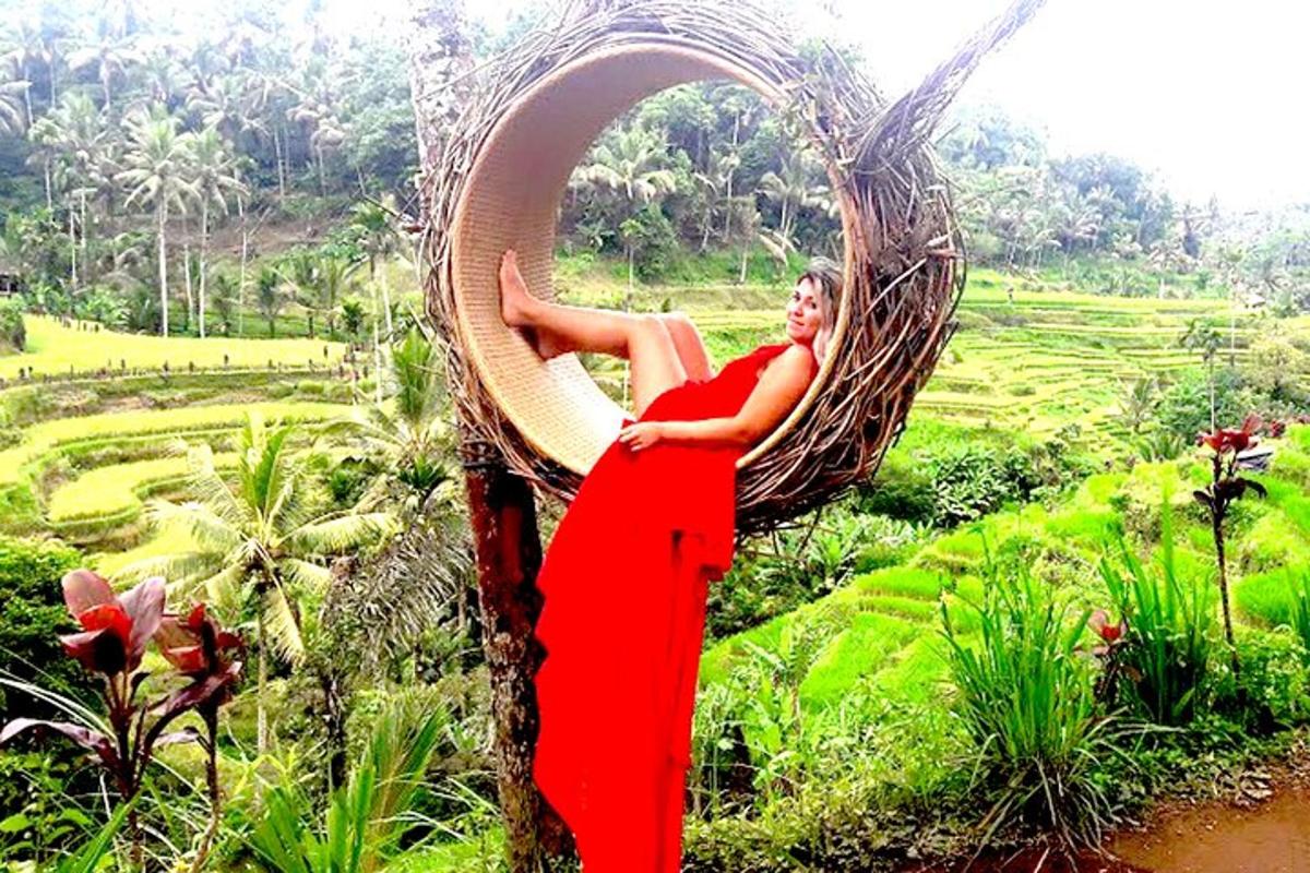 seorang wanita berbaju merah bersandar pada pokok