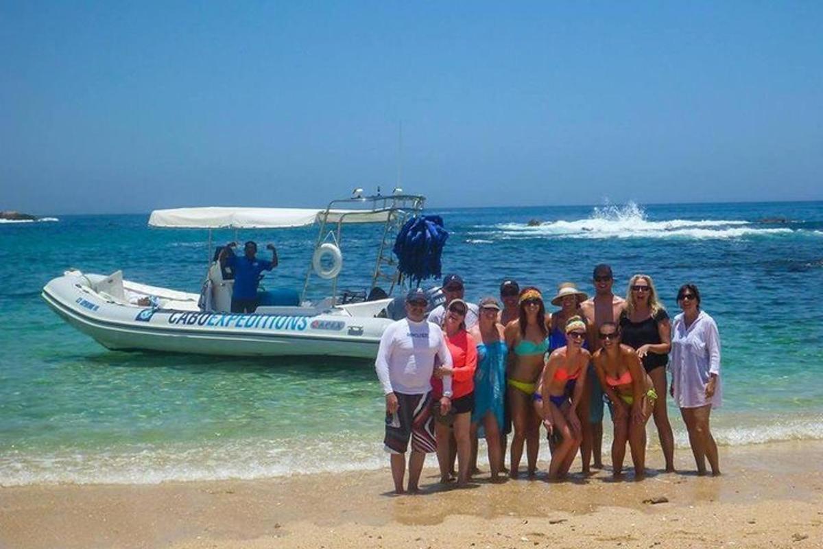 skupina ljudi, ki stojijo na plaži poleg čolna