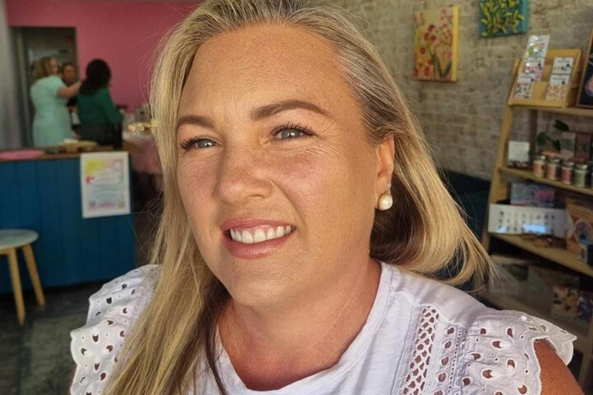 una donna in piedi in un negozio che sorride alla telecamera