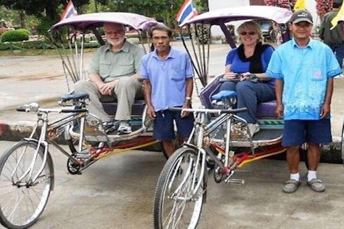 un gruppo di persone sedute su un risciò con una bicicletta