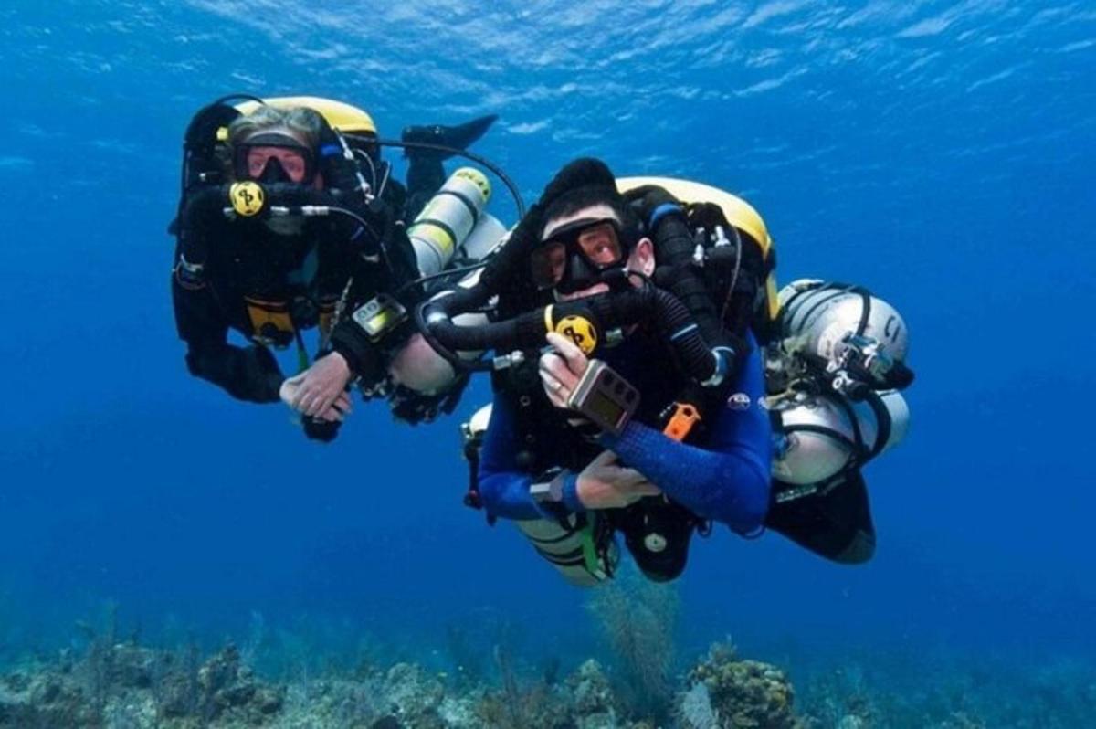 dva lidé v potápěčském vybavení potápějící se v oceánu
