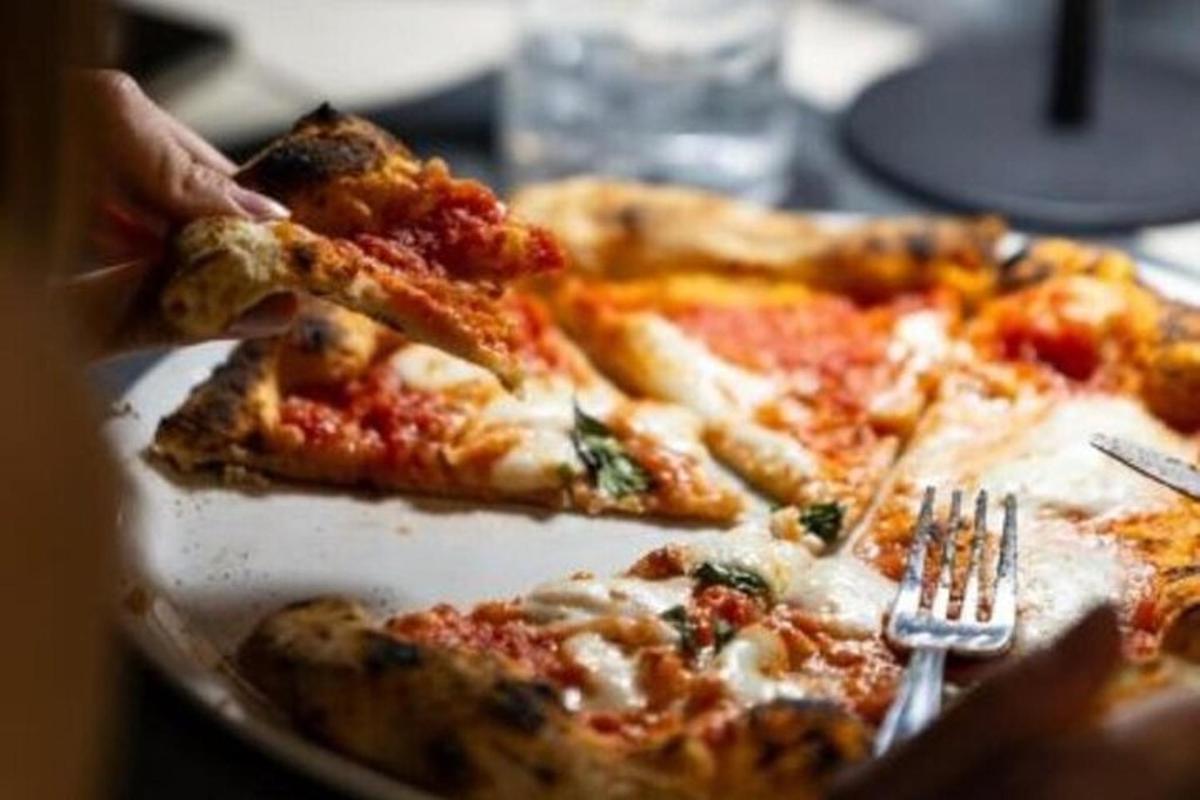 o persoană care mănâncă o felie de pizza pe o farfurie
