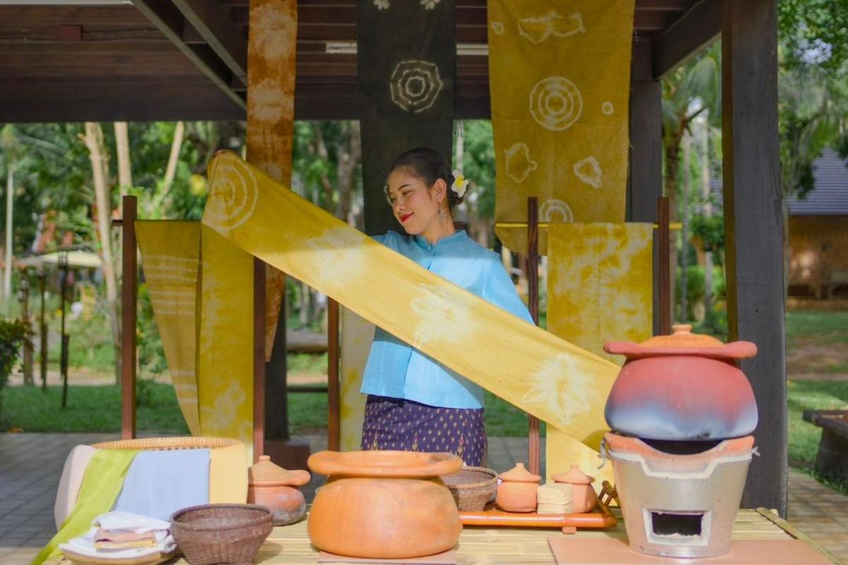 a woman holding a surfboard on a table with pottery