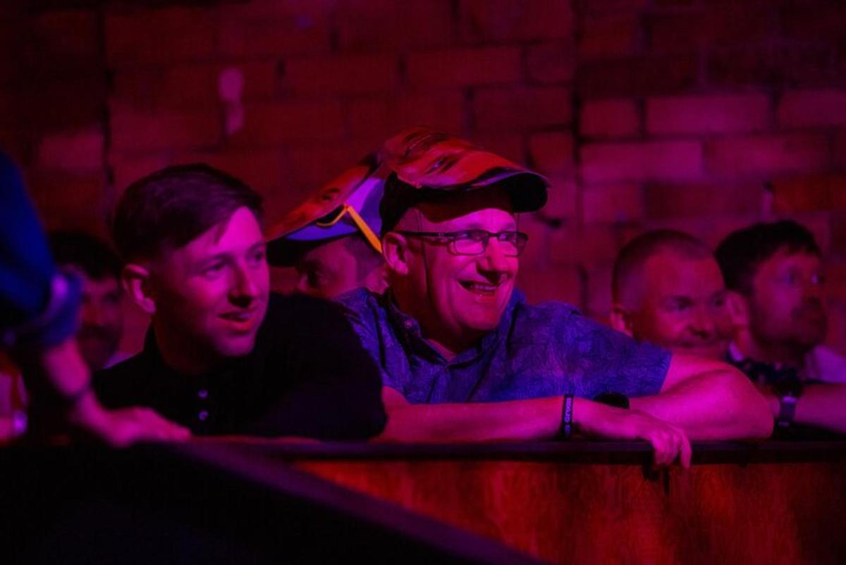 a group of people sitting in a room with red lights