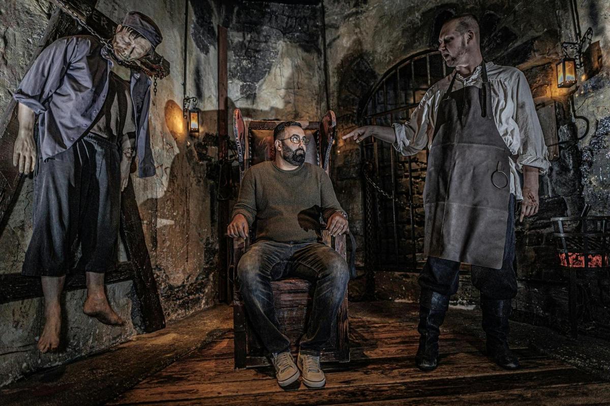 a painting of a man sitting in a chair next to two men