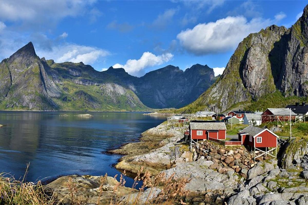 a village on the shore of a body of water with mountains