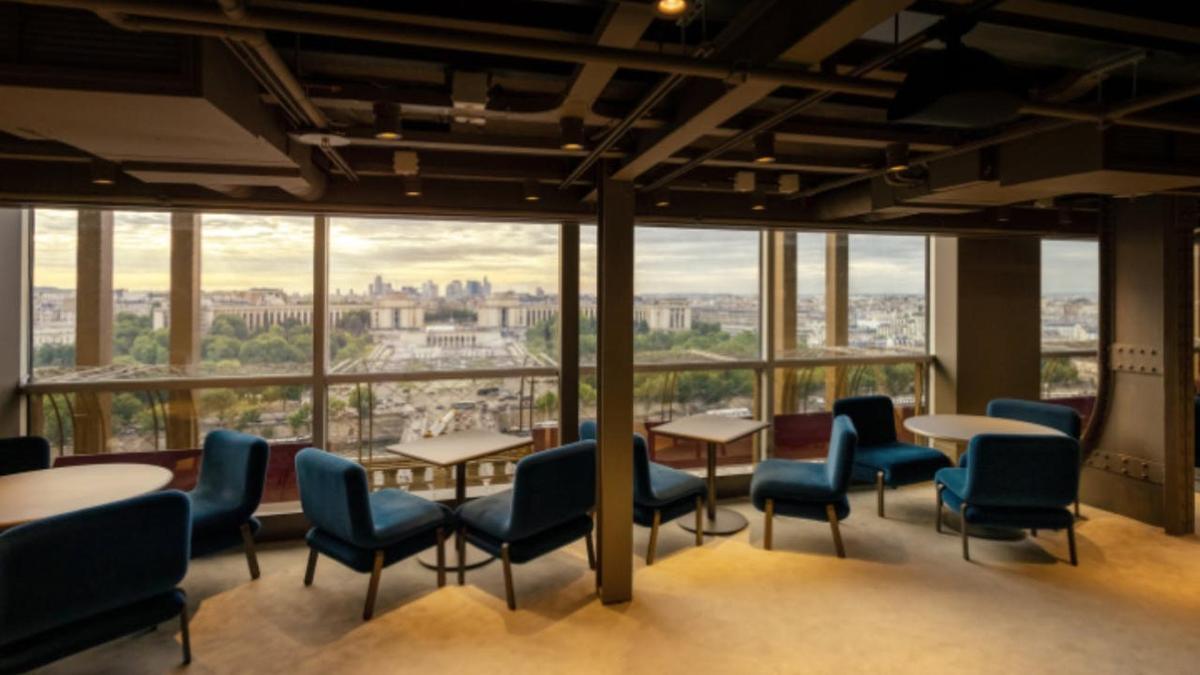 Una habitación con mesas y sillas y vista a la ciudad.