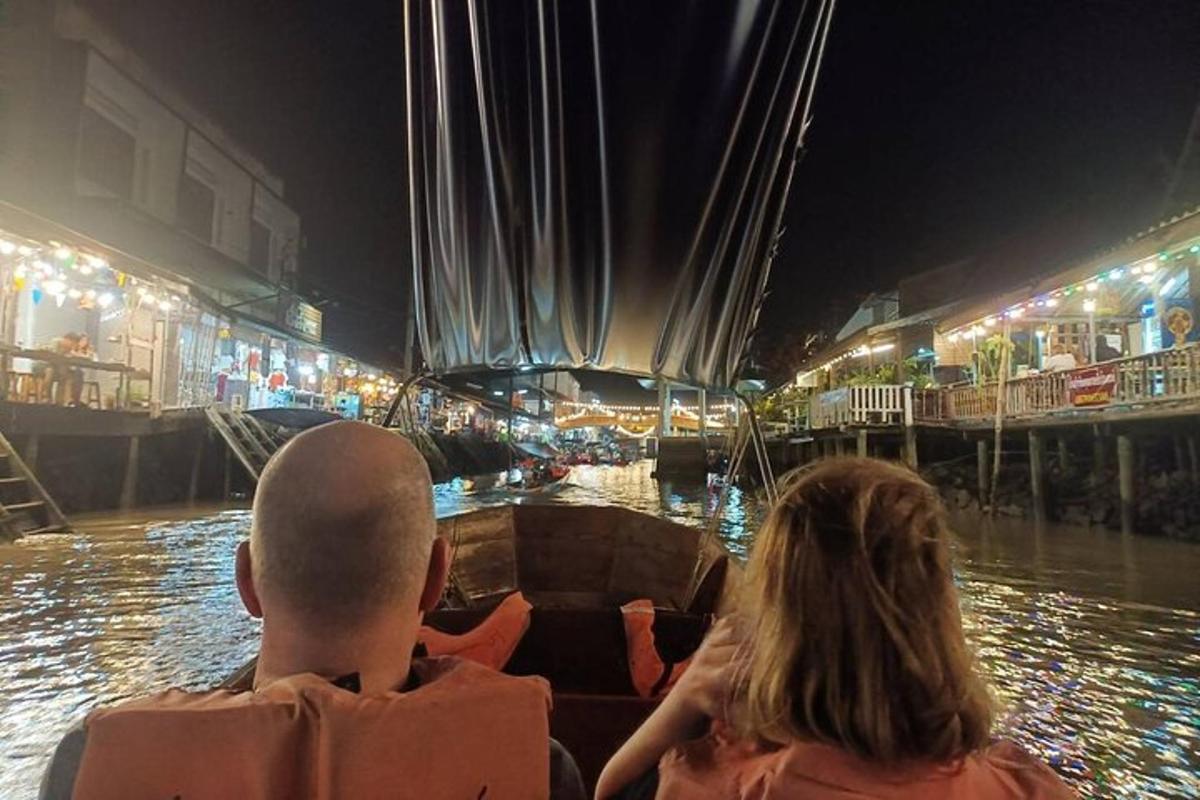 Un hombre y una mujer en un barco en el agua por la noche.