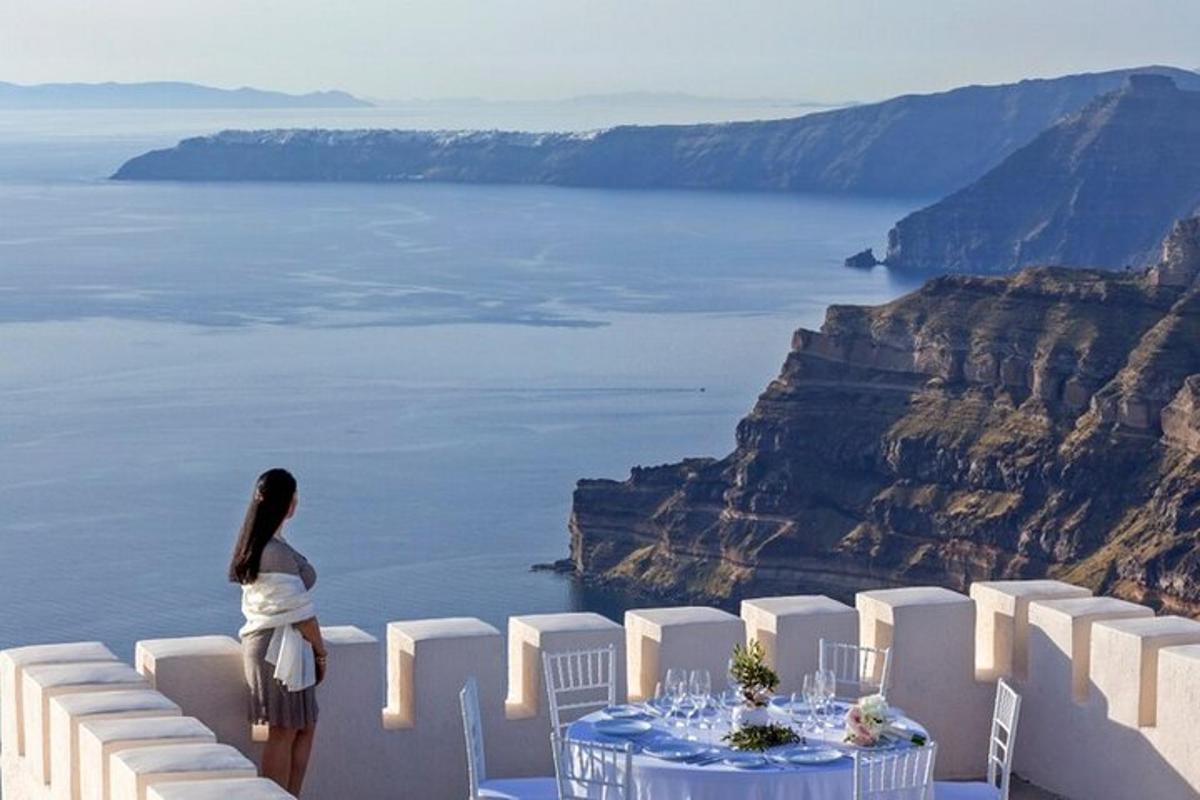 a woman standing at a table with a view of the ocean