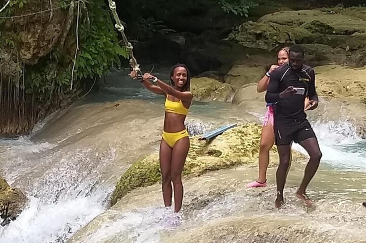 isang grupo ng mga tao na nakatayo sa mga bato sa isang ilog