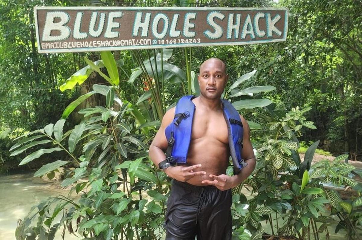 um homem parado em frente a uma placa de um barraco azul