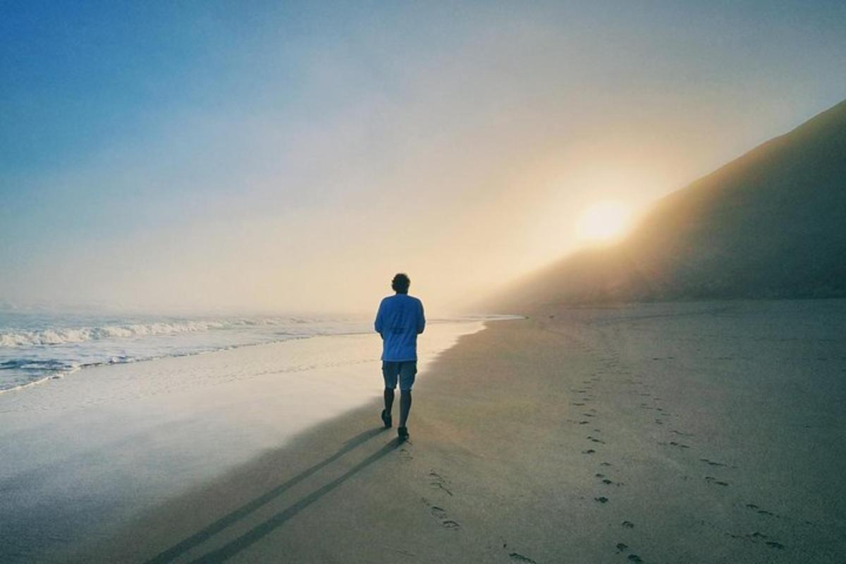 a man walking on the beach near the ocean
