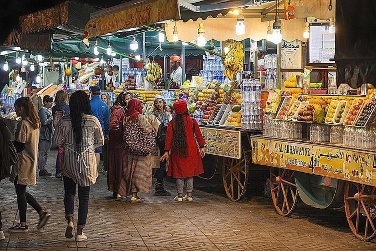 skupina ljudi, ki stojijo okoli tržnice s sadjem