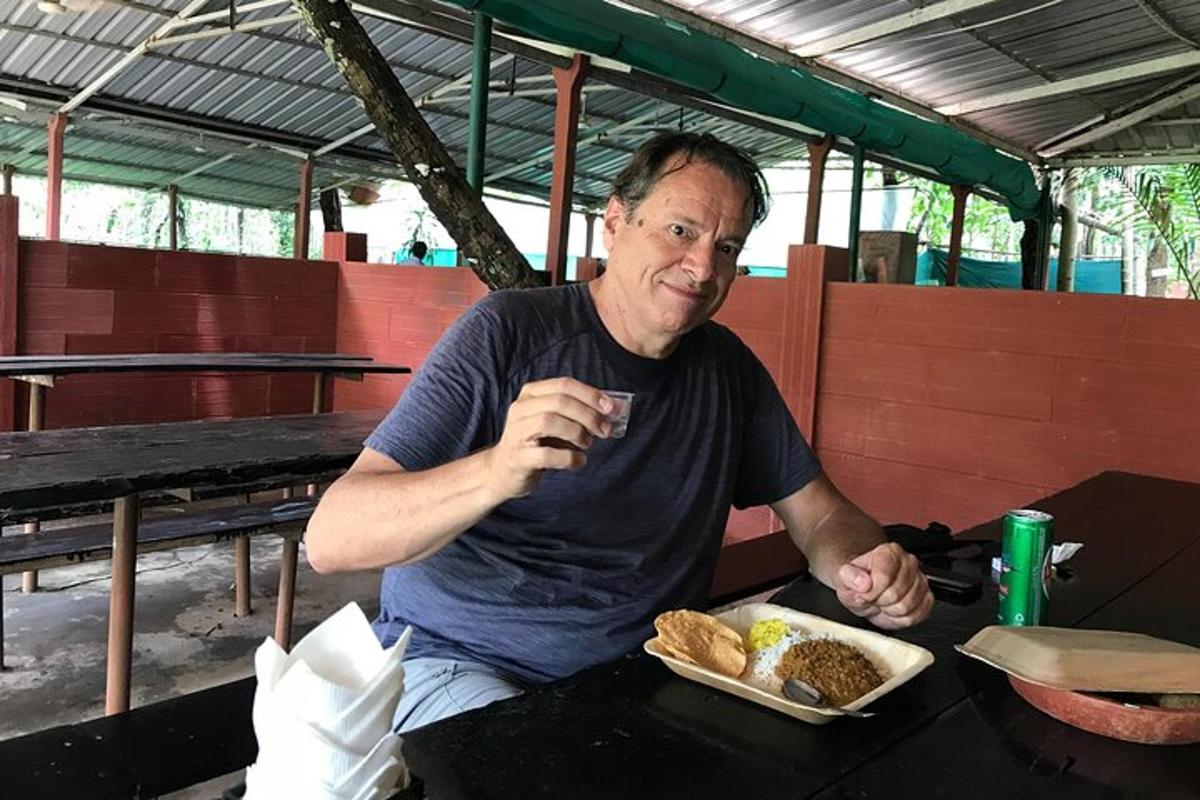 seorang lelaki duduk di meja dengan sepinggan makanan