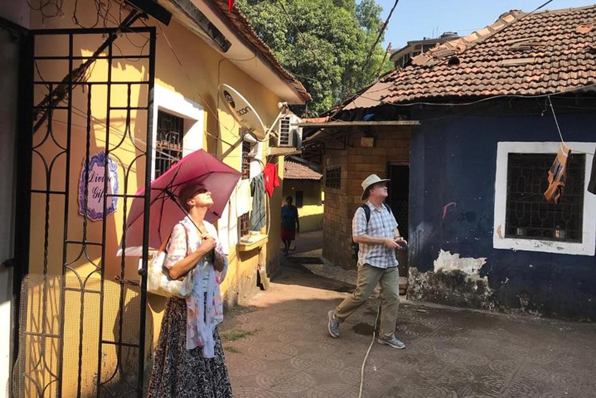 dua orang berdiri di luar bangunan dengan payung