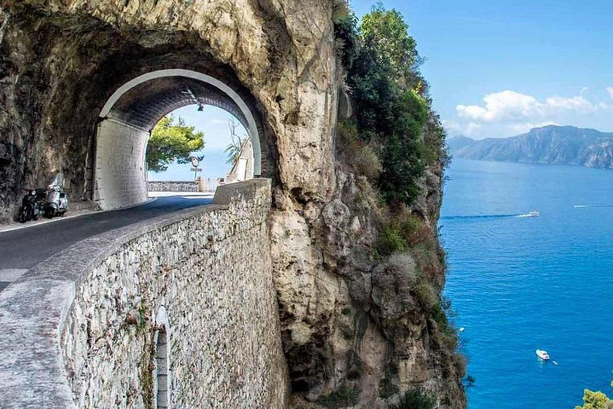 un túnel en la ladera de una montaña al lado del agua