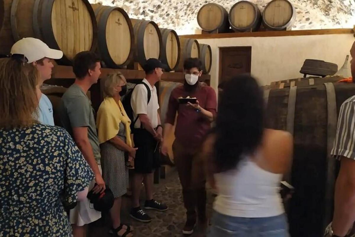 un gruppo di persone in piedi in una cantina vinicola
