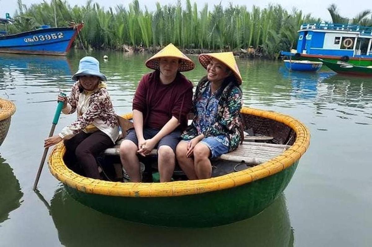 tre persone sedute su una barca sull'acqua