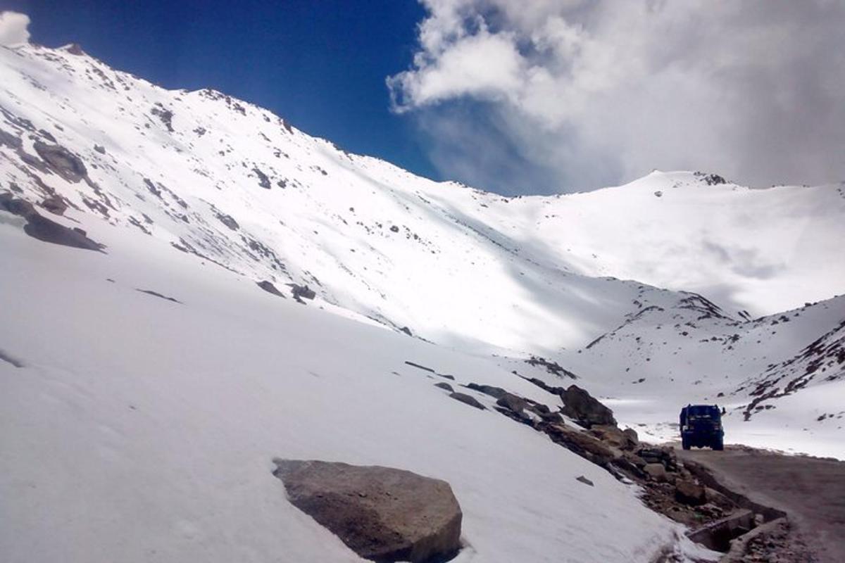a snow covered mountain with a van in the distance