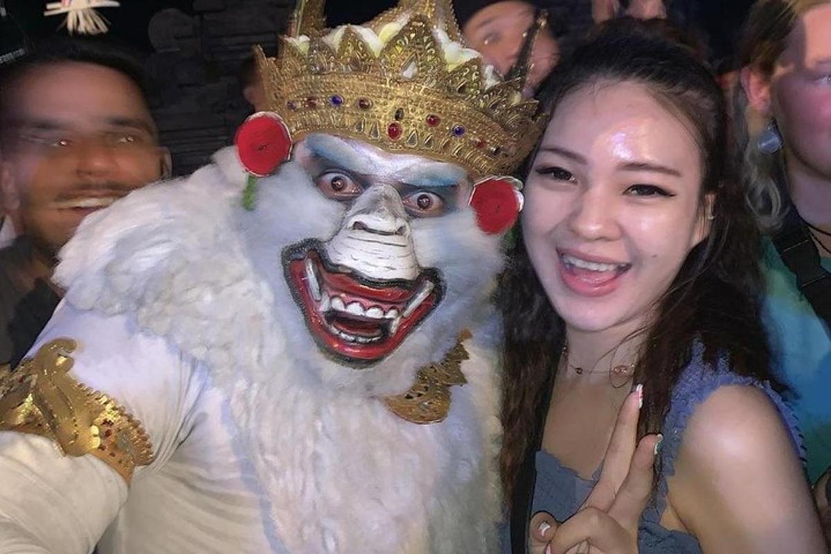Una mujer parada junto a una persona disfrazada de león.