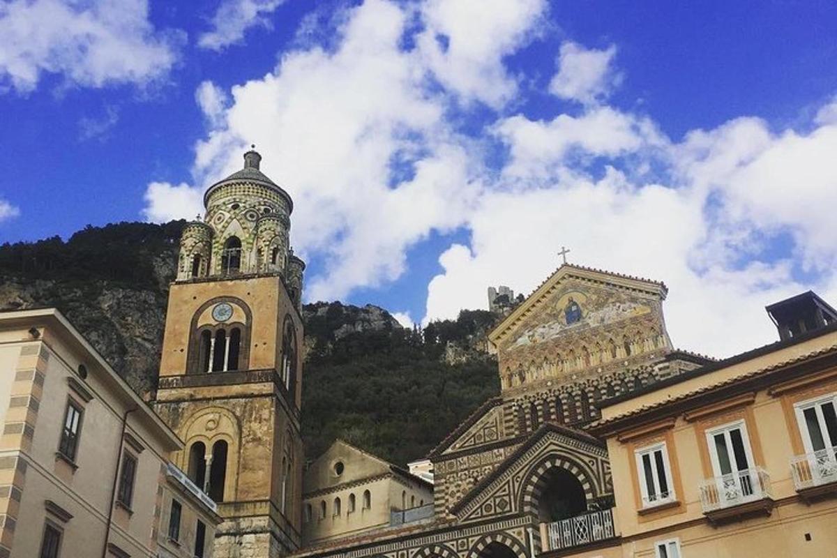 un edificio con una torre dell'orologio di fronte a una montagna