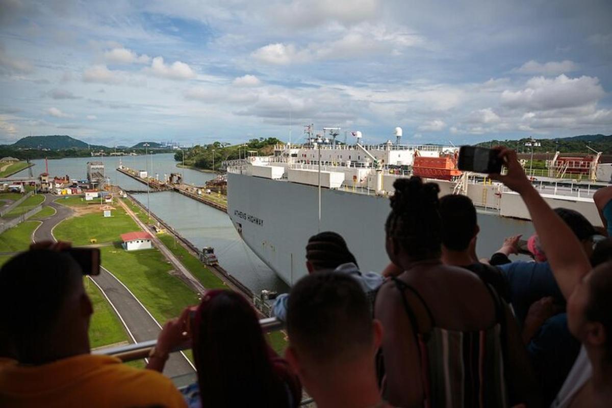 um grupo de pessoas tirando fotos de um navio de cruzeiro