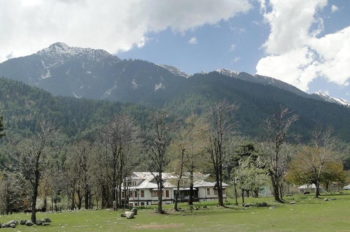 a house in a field with mountains in the background